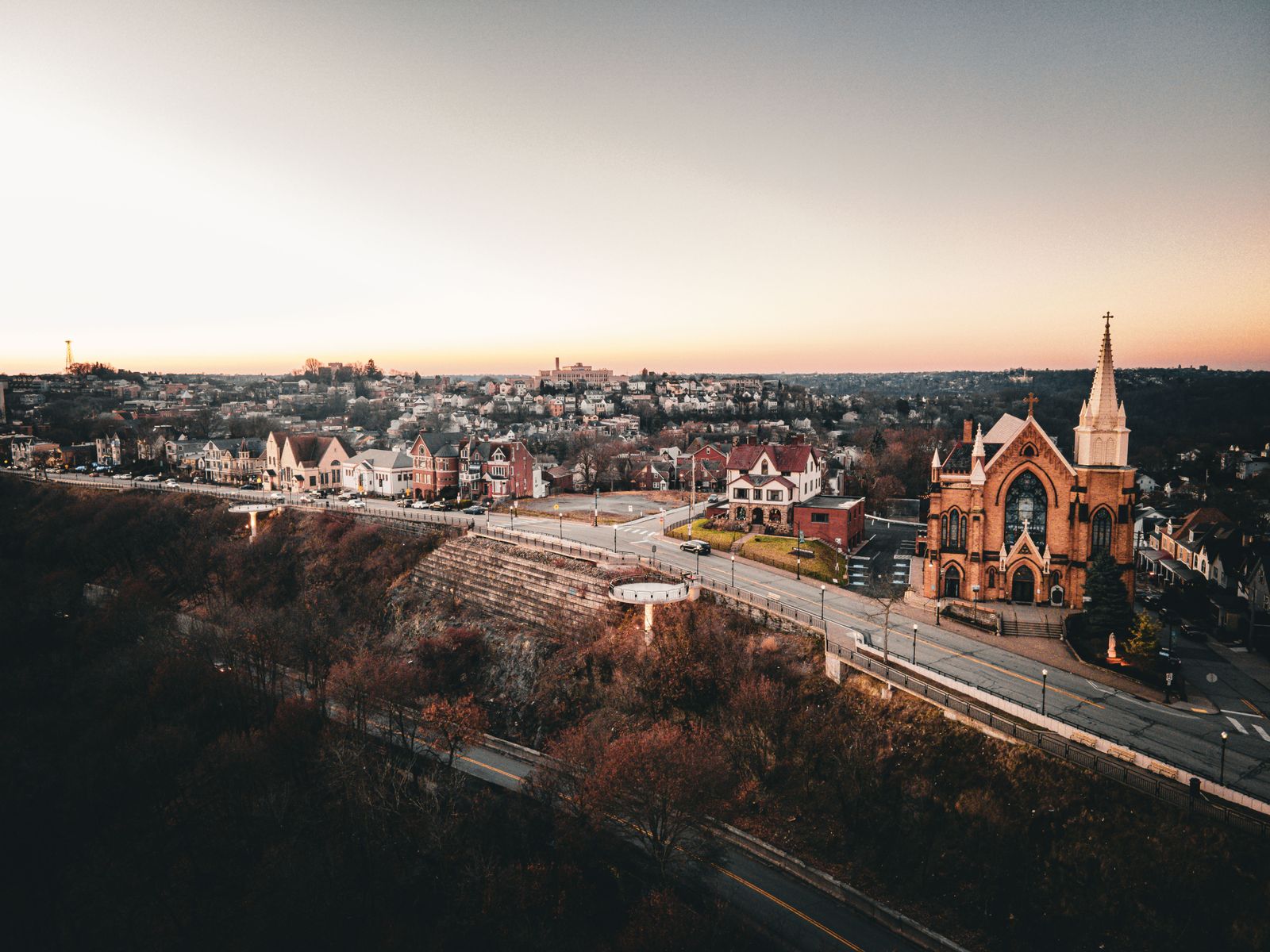Aerial view of a historic neighborhood with a church steeple and tree-lined streets