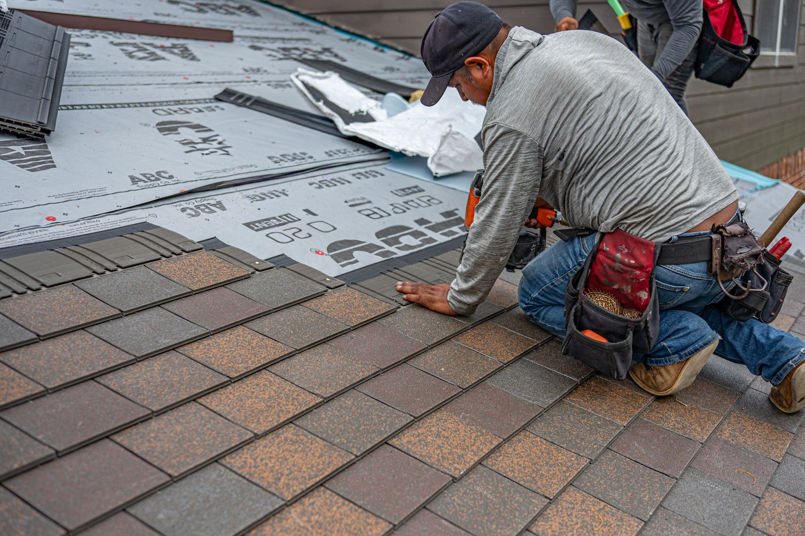 Roofer installing shingles